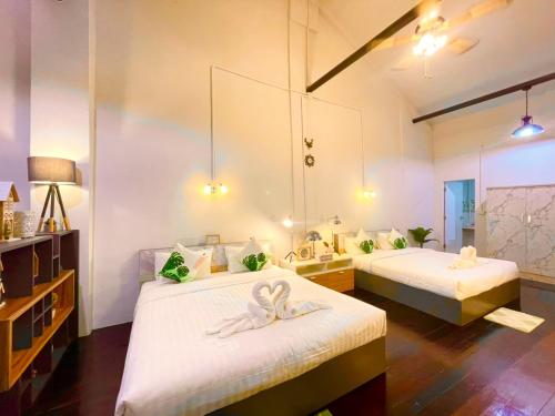 a room with two beds with white towels on them at Primego Boutique Hotel in Phuket