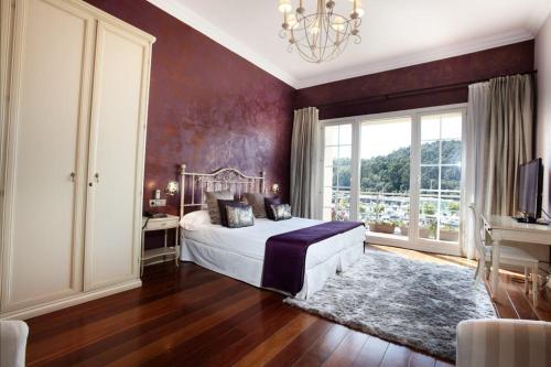 1 dormitorio con cama y ventana grande en KAIAN MAITEA en Plentzia