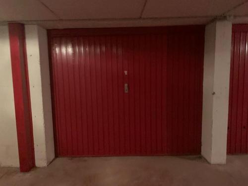 una porta rossa in una stanza con due colonne di APPARTAMENTO FOPPOLO a Foppolo