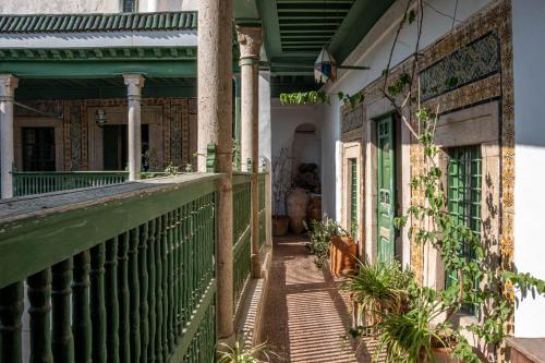 a porch of a house with a green railing at Dar Hayder-la Medina in Tunis