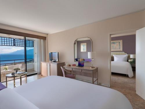 a hotel room with a bed and a desk with a television at Rixos Downtown Antalya - The Land Of Legends Access in Antalya