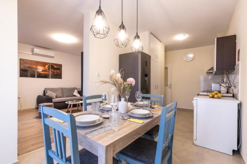 扎達爾的住宿－Sunset Apartment，厨房以及带木桌和椅子的用餐室。