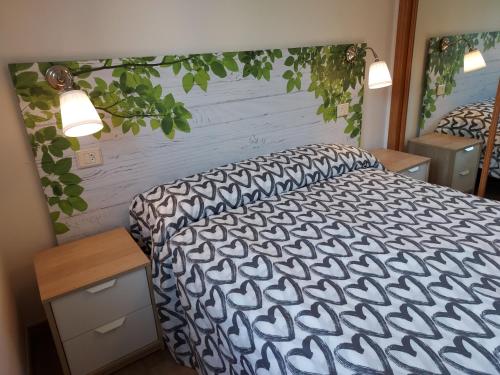 um quarto com uma cama com um edredão preto e branco em Apartamento Calzada Romana em Lugo