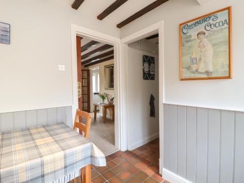 um quarto com uma mesa e uma imagem na parede em Vine Cottage em Whissendine