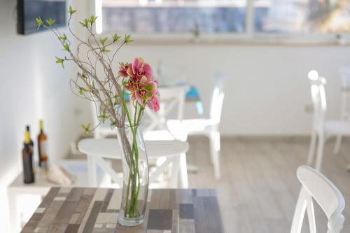 a vase with pink flowers sitting on a table at Fuori Rotta in Avola