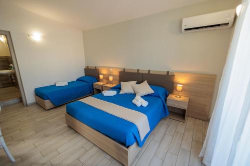 a bedroom with two blue beds and a mirror at Fuori Rotta in Avola