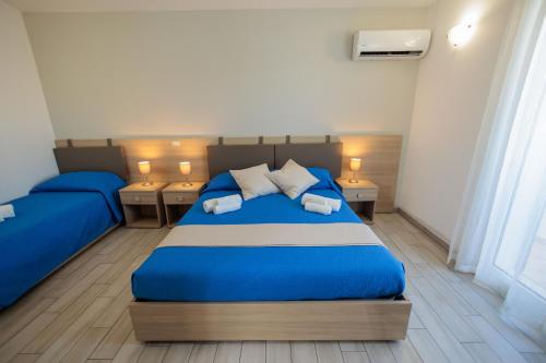 a bedroom with two blue beds and two night stands at Fuori Rotta in Avola