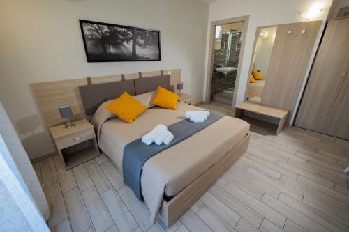 a bedroom with a bed with yellow pillows and a mirror at Fuori Rotta in Avola