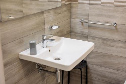 a bathroom with a white sink and wooden walls at Fuori Rotta in Avola