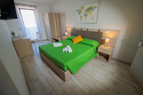 a bedroom with a green bed with two towels on it at Fuori Rotta in Avola