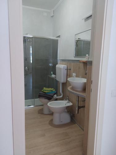 a bathroom with a toilet and two sinks and a shower at Cà del borgo Historic Village in Toscolano Maderno