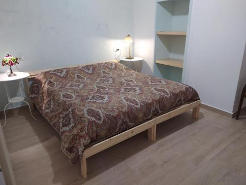 a bed with a blanket on it in a room at Cà del borgo Historic Village in Toscolano Maderno