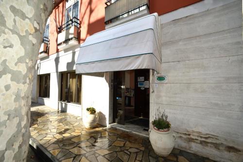 a cat sitting in the doorway of a building at Hotel Morchio Mhotelsgroup in Diano Marina