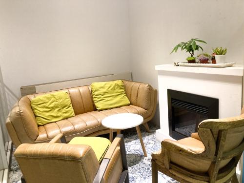 a living room with a couch and chairs and a fireplace at 4Plus Hostel in Taipei
