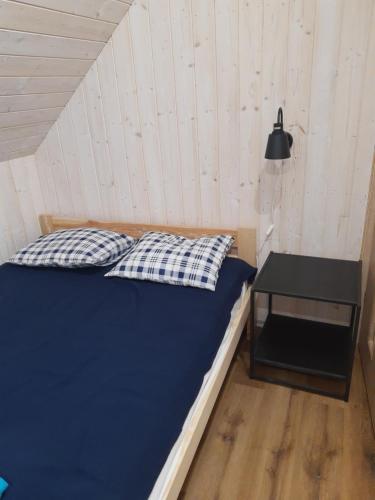 łóżko w pokoju ze stołem i lampką w obiekcie Lazurowe Apartamenty w mieście Niechorze