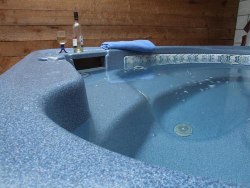 eine blaue Badewanne mit einem Glas Wein darin in der Unterkunft Anakiwa Lodge in Anakiwa