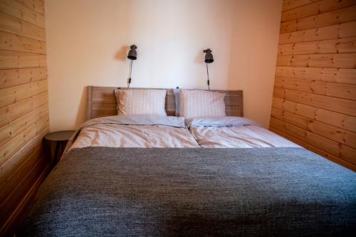 a bedroom with a bed with two lamps on the wall at Kåvanstugan Funäsdalen in Funäsdalen