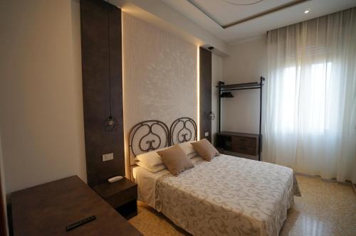 a bedroom with a large bed and a window at Hotel Villa Fulgida in Cattolica