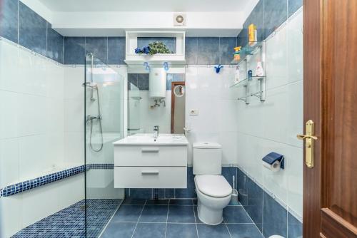 a bathroom with a toilet and a sink and a shower at Tropical Holiday Apartment in Los Cristianos
