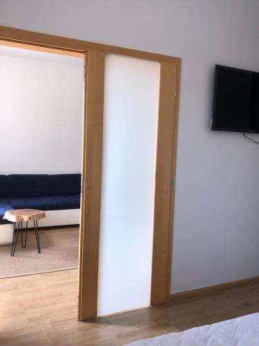 a sliding glass door in a room with a couch at Apartmán Lara in Komárno