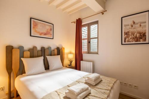 une chambre avec un grand lit avec des draps blancs dans l'établissement La Vague - Breath of Freshness in Center of Honfleur - Free Parking 550M, à Honfleur