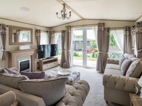 ein Wohnzimmer mit zwei Sofas und einem Fernseher in der Unterkunft Valley View with a luxurious hot tub in Newquay