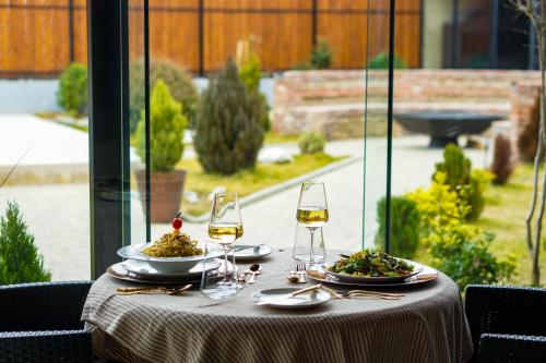 a table with two plates of food and wine glasses at Boutique Hotel Kviria in Tʼelavi