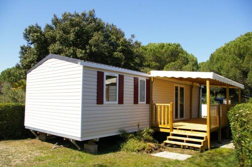een klein geel en wit tiny house met een veranda bij Mobile Home OuiReves 304 facing the Mediterranean in Lattes