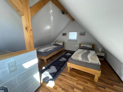 - 2 lits dans une chambre mansardée dans l'établissement Ferienwohnung Häusla, à Hirschaid