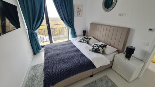 NOR - Luxury apartment في جوبيتر: غرفة نوم بسرير والستائر الزرقاء ونافذة