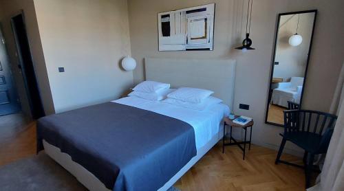 a bedroom with a large bed and a mirror at DESIGN hotel VERBENICUM in Vrbnik