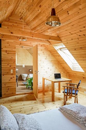 a room with a bed and a desk with a laptop at Vēju Paradīze in Pāvilosta