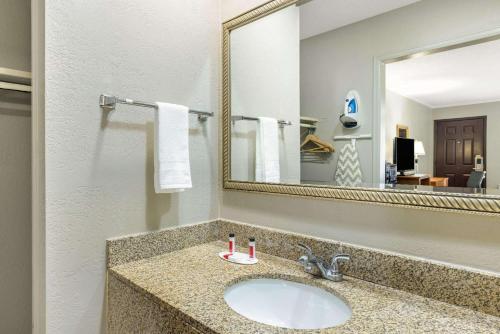 a bathroom with a sink and a mirror at Super 8 by Wyndham Kansas City Airport North in Kansas City