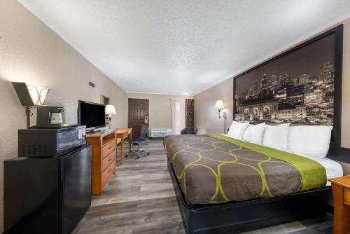 a hotel room with a bed and a desk at Super 8 by Wyndham Kansas City Airport North in Kansas City