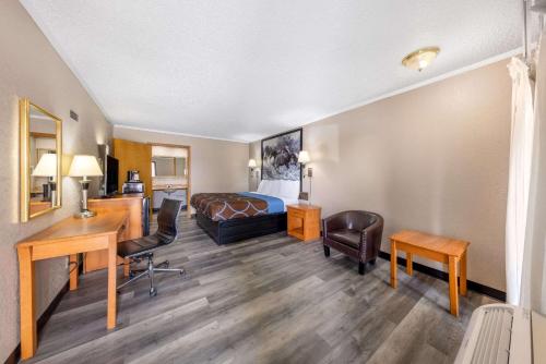 a hotel room with a bed and a desk at Super 8 by Wyndham Kansas City Airport North in Kansas City