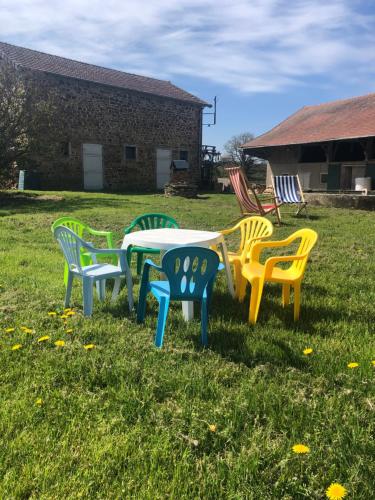 a group of chairs around a table in the grass at Gîte à la ferme chaleureux avec cheminée in Préveranges
