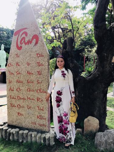 a woman standing in front of a sign at Anh Quân Hotel in Quy Nhon