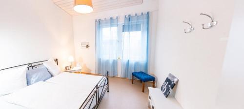 - une chambre avec deux lits et une chaise bleue dans l'établissement BnB Entensee, à Uznach