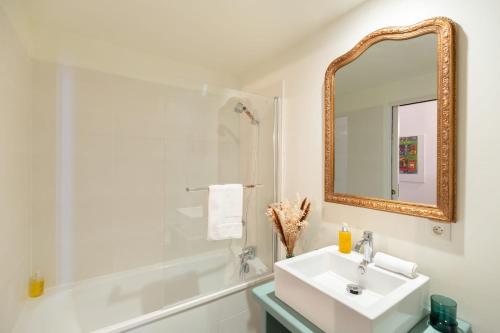 une salle de bain blanche avec un lavabo et un miroir dans l'établissement La Vague - Breath of Freshness in Center of Honfleur - Free Parking 550M, à Honfleur
