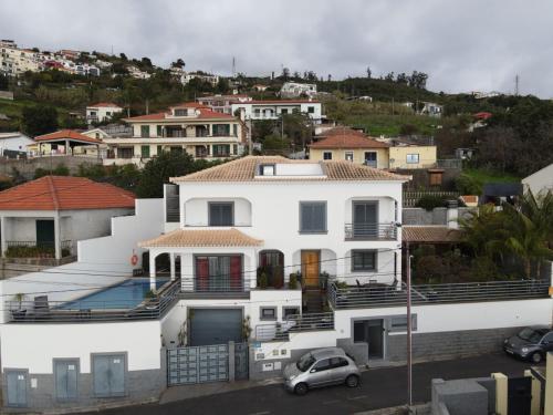 una casa blanca con un coche aparcado delante de ella en Sea and Sun 4 You - Choupana House en Funchal