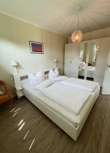 um quarto com uma grande cama branca num quarto em Ferienwohnung Apfelrose em Trent