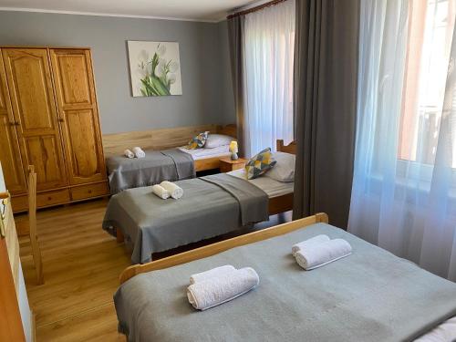 a hotel room with three beds and a window at Willa Mona in Międzywodzie