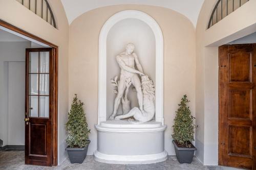 una estatua en un pasillo con dos árboles de Navidad en Oriana Homèl Torino, en Turín