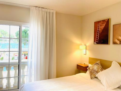 a bedroom with a bed and a large window at Hotel Venteo in Platja  d'Aro