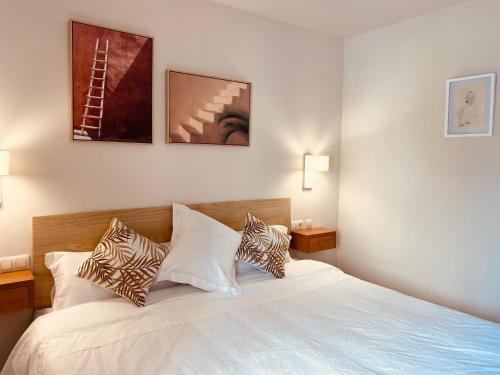 um quarto com uma grande cama branca com almofadas em Hotel Venteo em Platja d'Aro