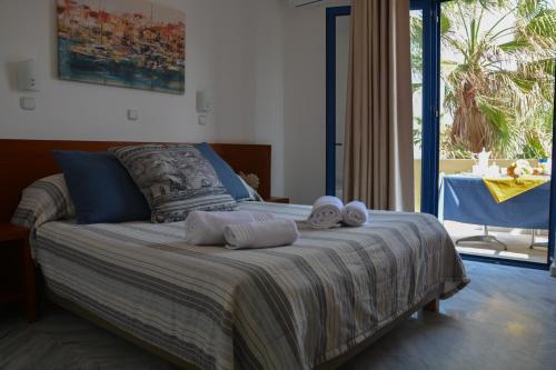 a bedroom with a bed with towels on it at Marina Sands in Agia Marina Nea Kydonias