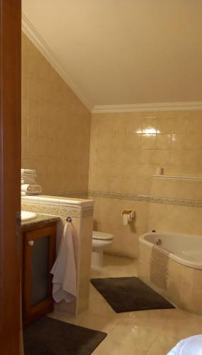 a bathroom with a tub and a toilet and a sink at Casa Belo Horizonte in Lourinhã