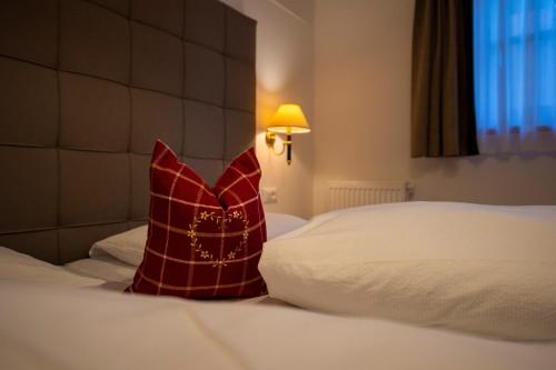 a red pillow sitting on top of a bed at Chalet Alpina in Ortisei
