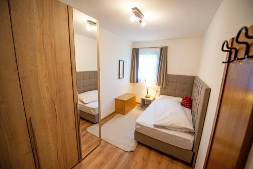 a small bedroom with two beds and a mirror at Chalet Alpina in Ortisei