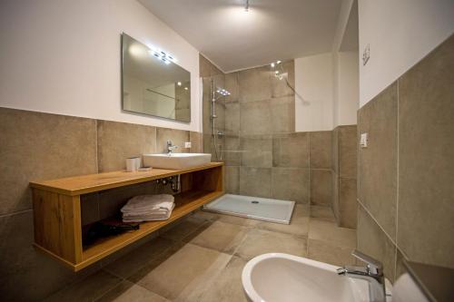 a bathroom with a sink and a tub and a mirror at Chalet Alpina in Ortisei